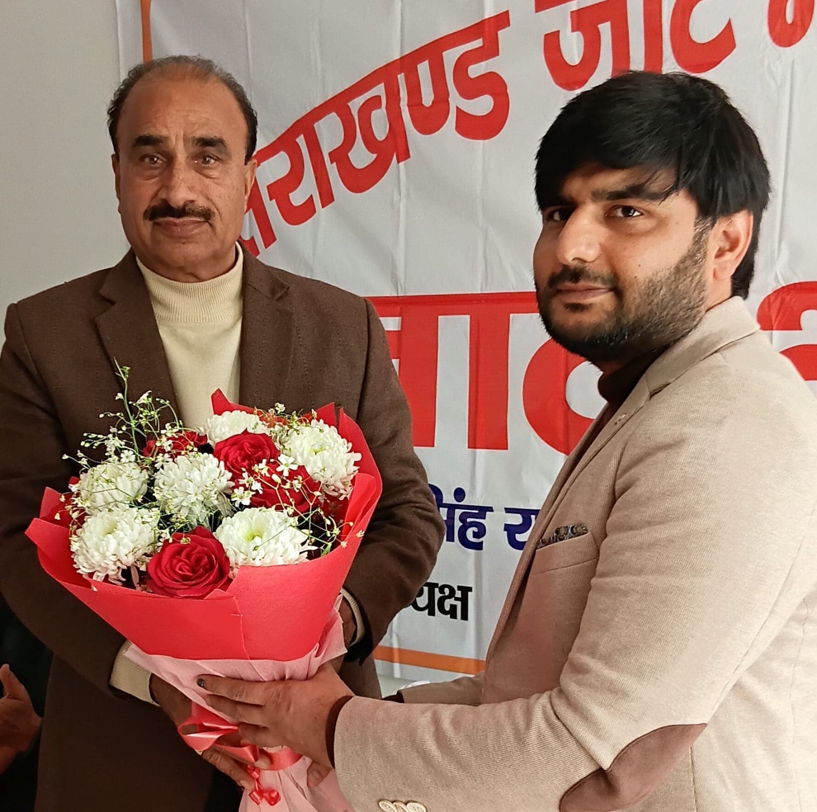 Arjun Chaudhary presenting bouquet to Shri Ompal Singh ji at Jat Mahasabha